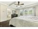 This is a main bedroom with dark wood floors, a ceiling fan, and access to the bathroom at 121 Martingale Dr, Holly Springs, NC 27540