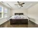 Comfortable bedroom with a tray ceiling, ceiling fan, and large windows providing natural light at 121 Martingale Dr, Holly Springs, NC 27540