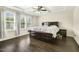 Comfortable bedroom with a tray ceiling, ceiling fan, and large windows providing natural light at 121 Martingale Dr, Holly Springs, NC 27540