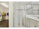 Bright primary bath featuring vanity, glass enclosed shower with bench, and walk-in closet at 121 Martingale Dr, Holly Springs, NC 27540