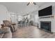 Open-concept living room with a fireplace, ceiling fan, and view of the kitchen and dining areas at 124 Boomer St, Benson, NC 27504