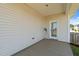 Covered patio area with white siding and a glass-paned door leading inside at 124 Boomer St, Benson, NC 27504