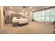 Bright bedroom featuring a large bed, a ceiling fan, and a window seat with shuttered windows at 125 Amesbury Ln, Cary, NC 27511