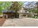 Two-story home with a brick and siding exterior, surrounded by mature trees, with a spacious patio at 125 Amesbury Ln, Cary, NC 27511