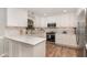 Modern white kitchen featuring stainless steel appliances and quartz countertops at 125 Amesbury Ln, Cary, NC 27511