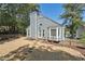 Back exterior view with a spacious rock area, mature trees providing ample shade, and a classic architectural style at 1304 Greenside Dr, Raleigh, NC 27609