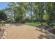 Landscaped backyard area with rock features, a wooden fence, shade trees, and a well-maintained lawn at 1304 Greenside Dr, Raleigh, NC 27609