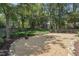 Spacious backyard features a rock garden, a fire pit, mature trees, and a grassy area for outdoor activities at 1304 Greenside Dr, Raleigh, NC 27609