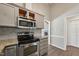 Modern kitchen with granite countertops, stainless steel appliances, and gray subway tile backsplash at 1304 Greenside Dr, Raleigh, NC 27609
