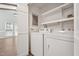 Bright laundry room featuring a white washer and dryer set, storage shelves, and easy access to the living space at 1304 Greenside Dr, Raleigh, NC 27609