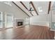 Bright living room with wood floors, exposed beam ceilings, and a brick fireplace at 1304 Greenside Dr, Raleigh, NC 27609