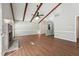 Open-concept living room with wood floors, beamed ceilings, and brick fireplace at 1304 Greenside Dr, Raleigh, NC 27609
