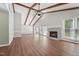 Spacious living room featuring a brick fireplace, wood floors, and beamed ceilings at 1304 Greenside Dr, Raleigh, NC 27609