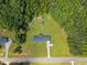 Aerial view of a single-story home with an extra storage building on a large lot with ample green space and mature trees at 137 Vaiden Rd, Louisburg, NC 27549