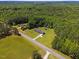 Aerial view of a single-story home and neighboring property surrounded by ample green space and mature trees at 137 Vaiden Rd, Louisburg, NC 27549
