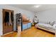 Bright bedroom featuring hardwood floors, a bed with gray bedding, and a dark blue dresser at 137 Vaiden Rd, Louisburg, NC 27549