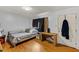 Well-lit bedroom with hardwood floors, a cozy bed, and a wooden side table at 137 Vaiden Rd, Louisburg, NC 27549