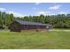 Ranch-style brick home with a well-maintained lawn and mature trees, showcasing its serene setting at 137 Vaiden Rd, Louisburg, NC 27549