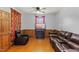 Cozy living room featuring wood paneling, a ceiling fan, and comfortable leather seating at 137 Vaiden Rd, Louisburg, NC 27549