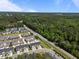 An aerial view showcases a townhome community surrounded by lush greenery and winding roads at 1394 Southpoint Trl, Durham, NC 27713