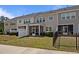 Townhome backyard with screened porches, grassy area, and a small black metal fence at 1394 Southpoint Trl, Durham, NC 27713