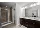Luxurious bathroom with tiled walk-in shower, and a double vanity sink with dark wood cabinets at 1394 Southpoint Trl, Durham, NC 27713
