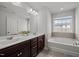 Bright bathroom featuring a double sink vanity, and a soaking tub for an at-home spa experience at 1394 Southpoint Trl, Durham, NC 27713