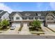 A row of modern townhomes featuring stone accents, white siding, and attached garages at 1394 Southpoint Trl, Durham, NC 27713