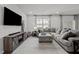 Comfortable living room with an oversized couch, media center, natural light, and neutral tones for relaxation at 1394 Southpoint Trl, Durham, NC 27713