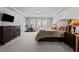 Spacious main bedroom with plush carpeting, tray ceiling, and windows for natural light and serene comfort at 1394 Southpoint Trl, Durham, NC 27713