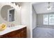 Bathroom vanity with white countertop, and round mirror; view to the bedroom at 1443 Smokey Mountain Dr, Zebulon, NC 27597