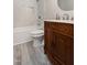 This bathroom features a marble tiled tub and shower, chrome fixtures, and a vintage vanity at 1443 Smokey Mountain Dr, Zebulon, NC 27597