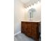 Bathroom features a wood vanity with white countertop, round mirror, and soft grey walls at 1443 Smokey Mountain Dr, Zebulon, NC 27597