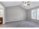 Vaulted ceiling bedroom with neutral grey paint, plush carpet, and double windows at 1443 Smokey Mountain Dr, Zebulon, NC 27597