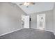 Large carpeted bedroom with neutral walls and view into the kitchen and bathroom at 1443 Smokey Mountain Dr, Zebulon, NC 27597