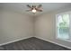 A small, unfurnished bedroom features neutral paint, carpet, a ceiling fan, one window, and white trim at 1443 Smokey Mountain Dr, Zebulon, NC 27597