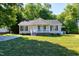 Inviting home boasts a classic design, green shutters, manicured lawn, and a glimpse of the driveway at 1443 Smokey Mountain Dr, Zebulon, NC 27597