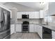 Bright kitchen features stainless steel appliances, granite countertops, and white cabinets at 1443 Smokey Mountain Dr, Zebulon, NC 27597