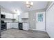 Well-lit kitchen features white cabinets, stainless steel appliances, and tiled backsplash at 1443 Smokey Mountain Dr, Zebulon, NC 27597