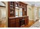 Elegant bar area features custom cabinets, a wine rack, granite countertops, and a built-in wine refrigerator at 1508 Samuel Wait Ln, Wake Forest, NC 27587