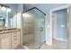 Modern bathroom with a large glass walk-in shower and vanity with drawers in a light blue setting at 1508 Samuel Wait Ln, Wake Forest, NC 27587