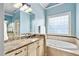 Elegant bathroom featuring a soaking tub, marble countertop, and bright natural light from a nearby window at 1508 Samuel Wait Ln, Wake Forest, NC 27587