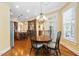 Sunlit dining area features a charming chandelier, an adjacent kitchen view, and hardwood floors throughout the open space at 1508 Samuel Wait Ln, Wake Forest, NC 27587