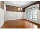 Formal dining room boasts wainscoting, hardwood floors, and a large window with plantation shutters at 1508 Samuel Wait Ln, Wake Forest, NC 27587