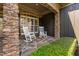Cozy front porch with stone pillars and white rocking chairs offers a relaxing outdoor space at 1508 Samuel Wait Ln, Wake Forest, NC 27587