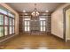 Home library featuring built-in bookshelves, hardwood floors, plantation shutters, and modern chandelier at 1508 Samuel Wait Ln, Wake Forest, NC 27587
