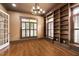 Home library featuring built-in bookshelves, hardwood floors, and plantation shutters at 1508 Samuel Wait Ln, Wake Forest, NC 27587