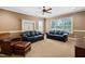 Comfortable living room with two leather sofas, a ceiling fan, and large windows, perfect for relaxation at 1508 Samuel Wait Ln, Wake Forest, NC 27587