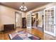 An elegant living room showcases a geometric rug, french doors, and views to the adjacent staircase at 1508 Samuel Wait Ln, Wake Forest, NC 27587