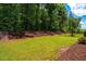 Spacious backyard with lush green lawn, privacy fence, and mature trees at 151 Monteith Dr, Chapel Hill, NC 27516